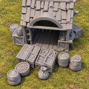 Échoppe marchande miniature avec caisses, tonneaux et sacs sur un tapis de jeu